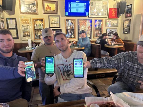A table of four friends at Club 400 each showing their Fantasy Draught scores on their phones